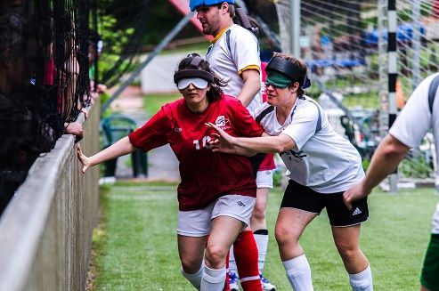 Action shot showing two women players disputing possession by the sideboards.