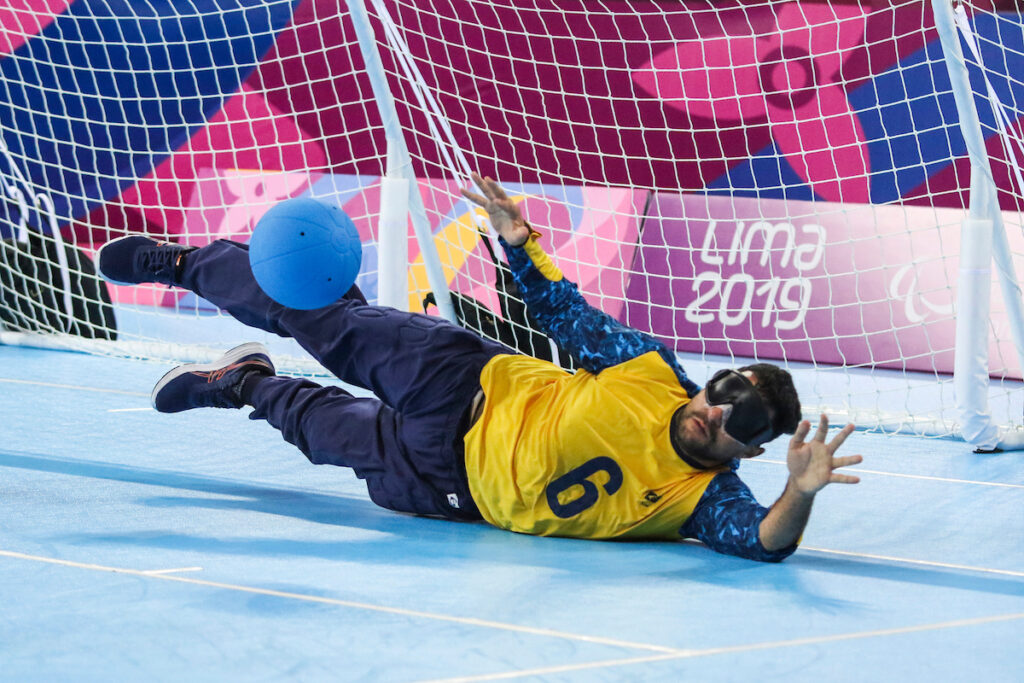Romario Marques stretches across the front of goal as the goalball bounces in front of him