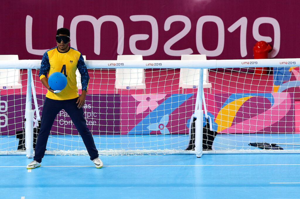 Leomon Moreno stands in goal holding the goalball at Lima 2019