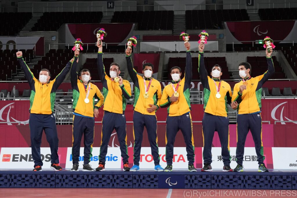 Brazilian men on the podium with their arms in the air at goalball at Tokyo 2020
