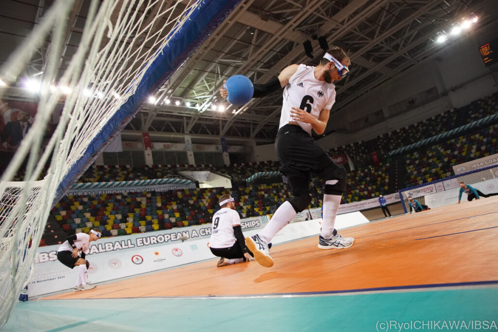 A German goalball player rotates towards the opposition goal during a shot