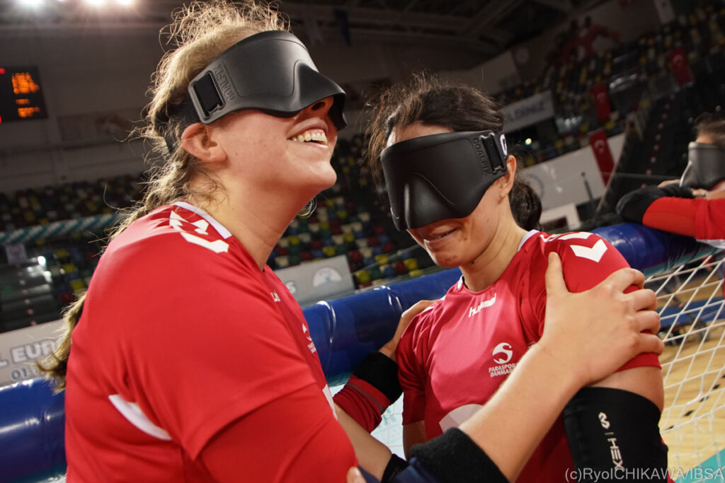 Members of Denmark's women's goalball team smile and embrace