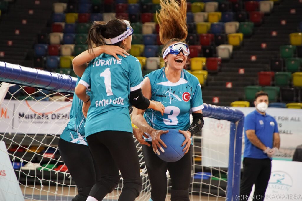 The Turkish women's goalball team jump up and down in celebration