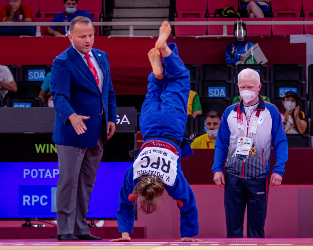 Viktoriya Potapova does a handstand on the side of the judo mat